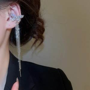 Detail view of silver butterfly ear cuff with zircon tassel on a model's ear