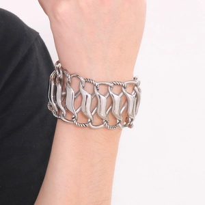 Detailed macro view of wide polished silver stainless steel bracelet with flame textures
