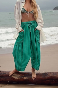 Detail of green striped wide leg pants featuring high waist drawstring and large side pockets