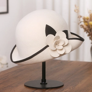 Elegant off-white wool felt cloche hat with black trim and camellia flower detail