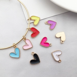 Colorful heart-shaped charms with enamel finish displayed on a gold bracelet ring