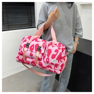 Fashionable pink leopard print sports duffle bag with dry wet separation being held by a model