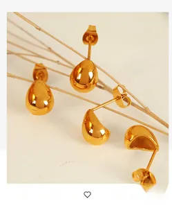 Detail view of gold teardrop earrings with a mirror-polished finish on tree branches