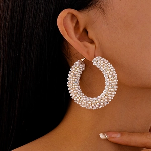 French style gold-plated hoop earrings with pearls and diamonds worn by a model