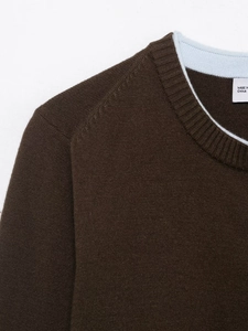 Detailed close-up of brown knit cardigan collar with light blue contrast inner lining