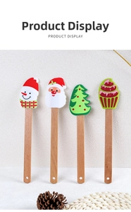 Close-up of four Christmas silicone spatulas with snowman and Santa designs on wooden handles
