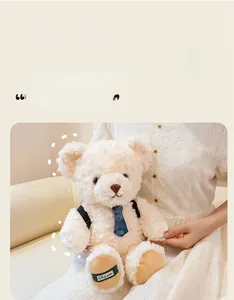 Detail of plush cream teddy bear with blue tie, black straps and soft fur texture