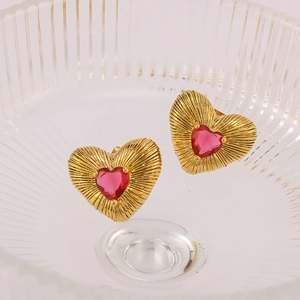 Golden heart-shaped earrings with red heart gemstone and textured finish in glass
