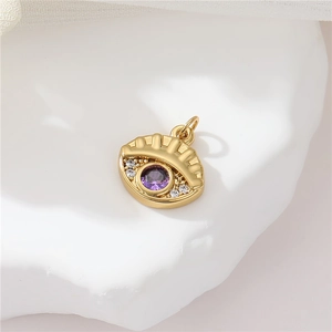 Macro shot of gold eye pendant with purple zircon on a ceramic tray backdrop