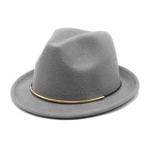 Detail view of grey wool fedora hat featuring black string and gold metal buckle trim