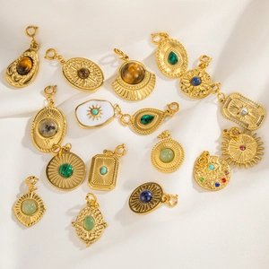 Close-up of vintage gold pendants with natural stones and mystical sun eye engravings