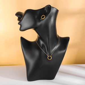 Golden necklace and stud earrings set with circular pattern on a black mannequin