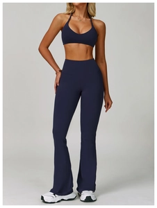 Detail of navy blue halter V-neck sports bra and flared yoga leggings set on model