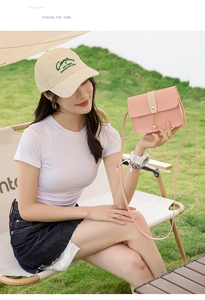 Detail of pink PU leather crossbody bag featuring beige contrast strap and pearl pendant charm