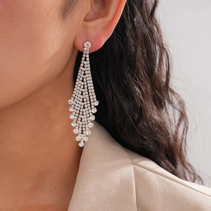 Close-up of model wearing luxury silver tassel earrings with sparkling white rhinestones