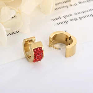 Close-up of gold huggie hoop earrings featuring densely paved red zircon crystals