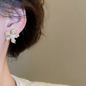 Elegante goldene Blumenstecker mit zentraler Perle und funkelnden Zirkon-Blüten