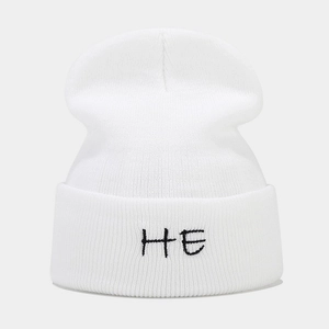 Close-up of HE letter embroidery on white ribbed knit beanie for winter warmth