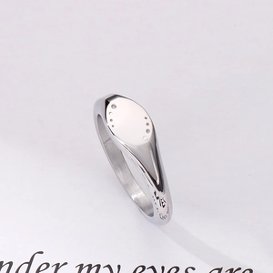Macro shot of silver signet ring showing dot texture and interior metal engraving details