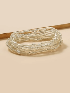 Detail of bohemian multilayer white seed bead waist chain on a natural wooden display