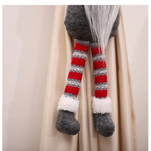 Detailansicht der gestrickten Beine und Plüschstiefel einer Weihnachtsgnom-Dekoration