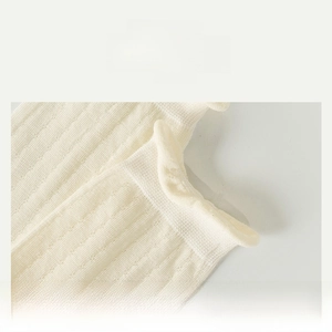 Dettaglio di calzini a coste color crema con bordo comfort ad alta elasticità