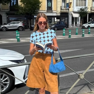 Chic blue studded shoulder bag paired with polka dot t-shirt and brown high waist shorts