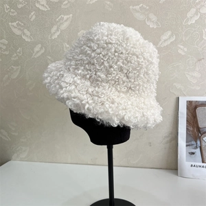 Detail of white curly faux fur bucket hat texture on a minimalist mannequin head