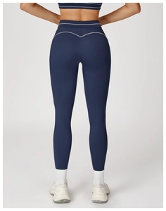 Detail of high-waist yoga leggings with white contrast stitching and push-up effect