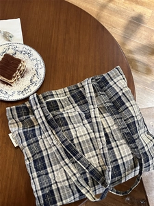 Detailed shot of navy quilted plaid tote bag on wooden table with afternoon tea aesthetic