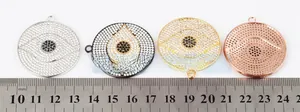 Macro detail of four large evil eye disk pendants with micro-pave crystals and ruler scale