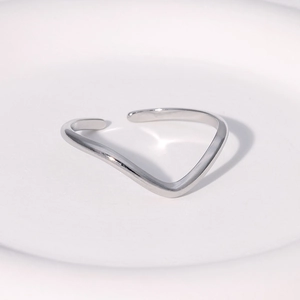Minimalist silver wave open ring in polished stainless steel on white pedestal