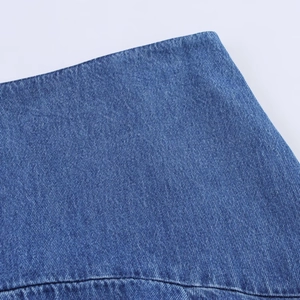 Detaillierte Makroansicht der blauen Denim-Stoffstruktur und Köperbindung am Midirock