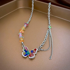 Detail of butterfly pendant necklace with colorful stones and rhinestones on gold tray