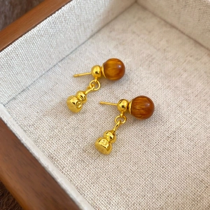 Détail de la boucle d'oreille plaquée or 18K avec perle brune et breloque gourde