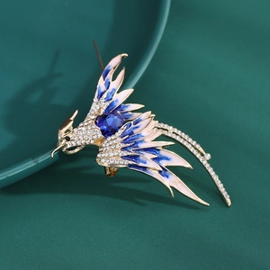 Macro detail of elegant phoenix brooch with blue enamel wings and sparkling rhinestones