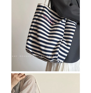 Detail of striped canvas tote bag with cat embroidery and thick rope handles