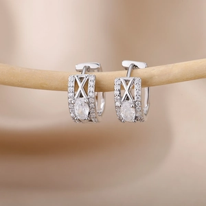 Detail of silver C-shaped hoop earrings with oval zircon and X-shaped hollow design