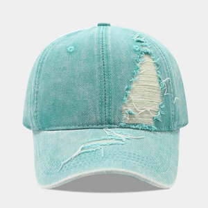 Close-up of distressed light blue denim baseball cap with vintage ripped details