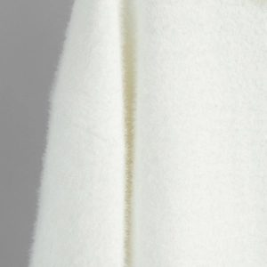 Macro shot of white high-density faux fur knit fabric with soft textured plush fibers