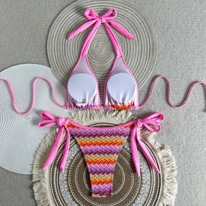 Flat lay of a halter bikini set with pink top and colorful zigzag patterned bottoms