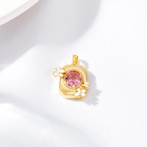 Pink oval gemstone pendant with gold metal base and white enamel flower accents