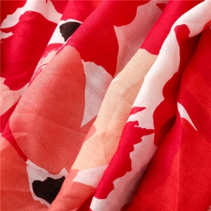 Close-up of red bohemian floral print fabric with twill texture and soft drape