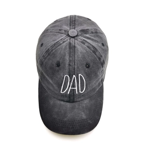 Close-up of white DAD 3D embroidery on washed dark grey cotton baseball cap texture