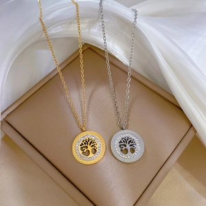 Detail of tree of life pendants in gold and silver with cubic zirconia in a jewelry box