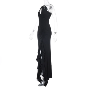 Détail d'une robe longue noire asymétrique avec fronces latérales et ourlet à volants