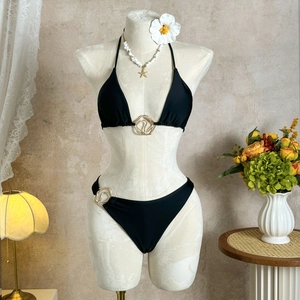 Detail of solid black bikini with luxury gold metal ring accents and triangle halter top