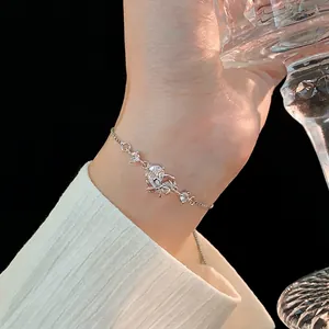 Adjustable silver heart bow bracelet with zircon stones worn on a woman's wrist