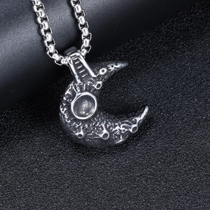 Close-up of vintage stainless steel moon pendant with detailed crater texture on leather