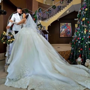 Elegante abito da sposa bianco a maniche lunghe con lussuoso strascico in pizzo